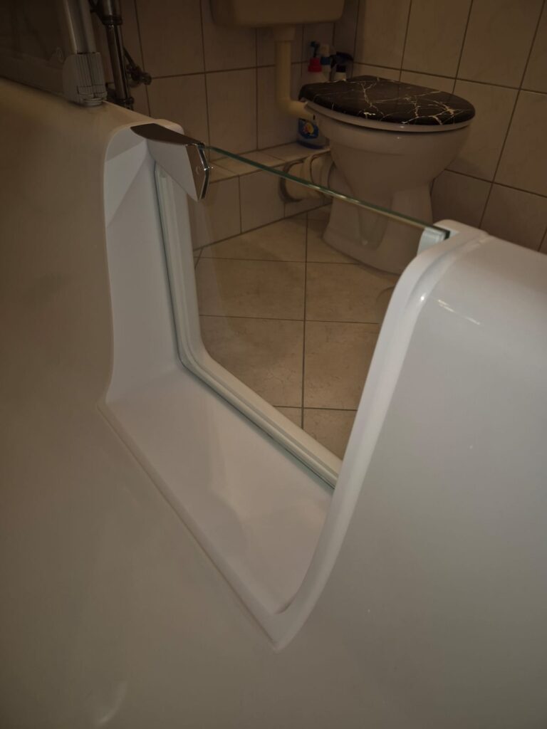 Nahaufnahme einer Badewanne mit nachgerüsteter Badewannentür für einen barrierefreien Badewannenumbau. Einstiegshilfe Badewanne und seniorengerechte Badlösung. - Wannentüren.de