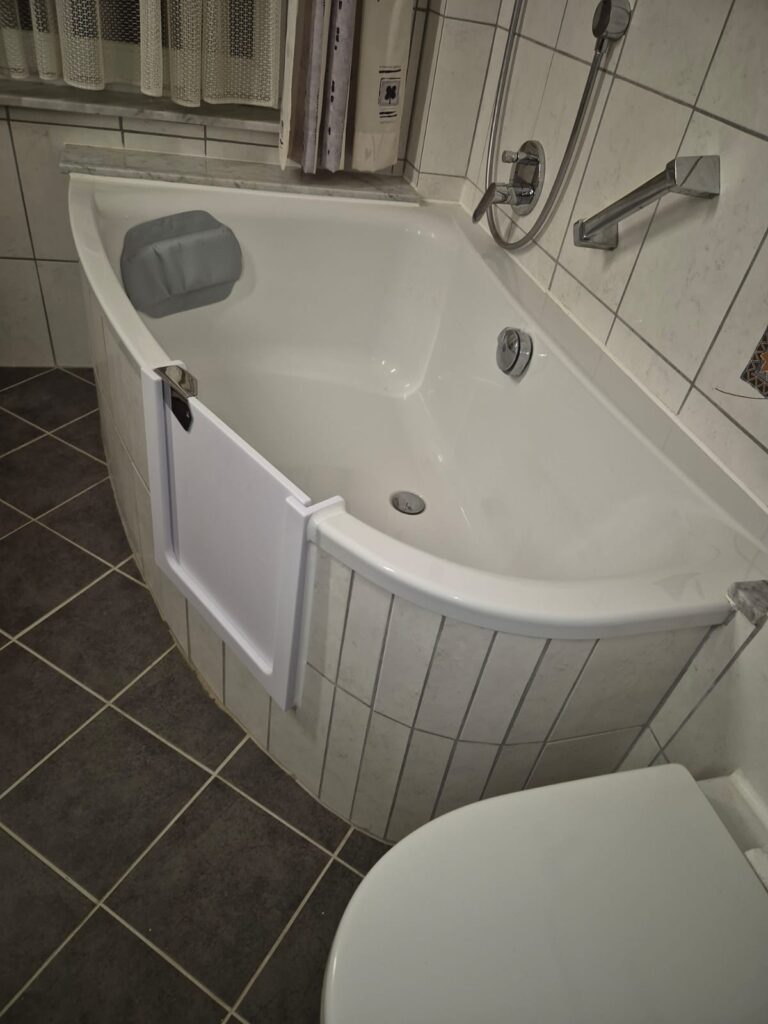Barrierefreie Badewanne mit nachgerüsteter Badewannentür als Einstiegshilfe. Seniorengerechte Badlösung für einen barrierefreien Badewannenumbau mit optionalem Pflegegrad Zuschuss. - Wannentüren.de